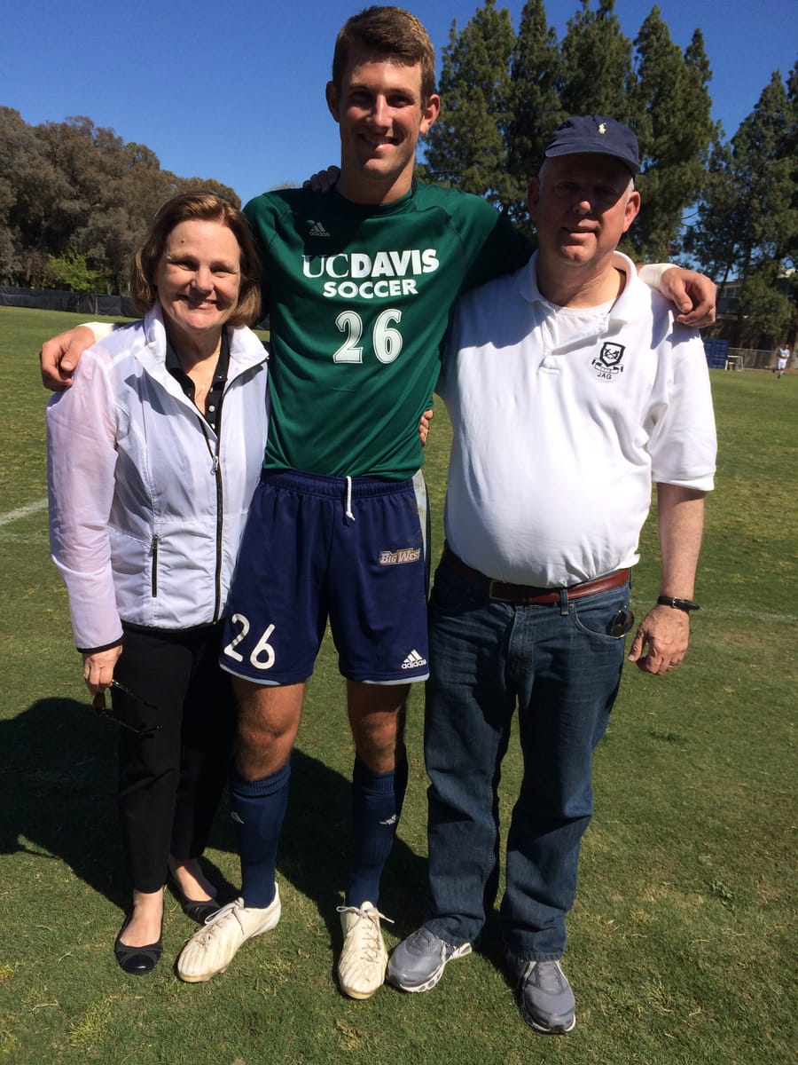 John in his UC Davis soccer jersey with his mom and dad