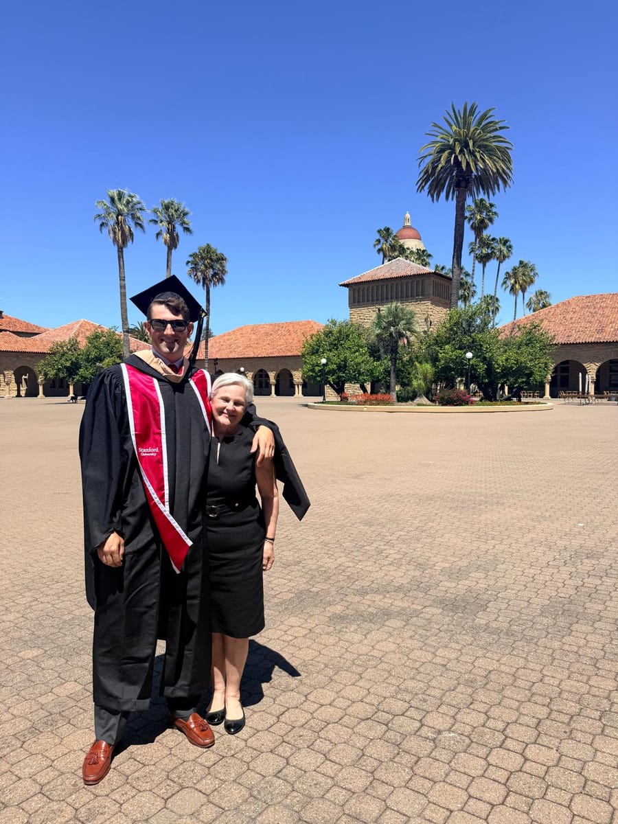 John in his Stanford gown with his mom in the Main Quad